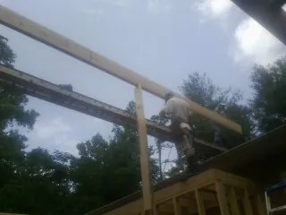 Carpenter setting a ridge beam over a new addition frame — Ice Dam Removal by Roofing Brothers in Wapato